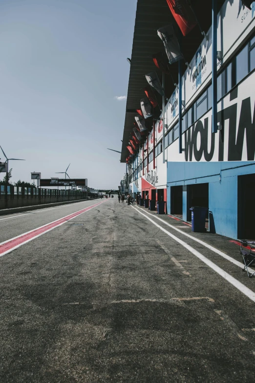 a man riding a motorcycle down a race track, by Carlo Martini, unsplash, graffiti, square, formula 1 garage, in a row, banners