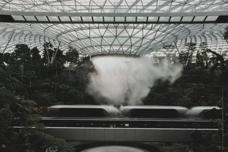 a train on a track with smoke coming out of it, inspired by Thomas Struth, pexels contest winner, interactive art, water flows inside the terrarium, black. airports, set on singaporean aesthetic, lush garden spaceship