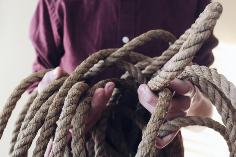 a person holding a bunch of rope in their hands, instagram picture, thumbnail, heavy grain, trending photo
