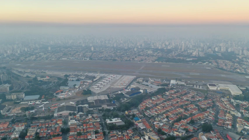 an aerial view of a city with lots of buildings, by Fernando Gerassi, reddit, happening, airport, ground haze, low quality photo, brazilian