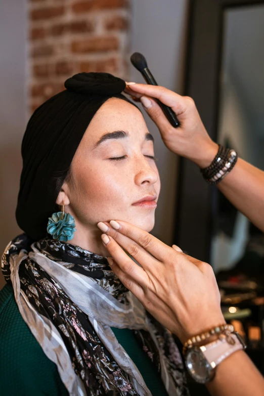 a woman getting her make up done by a hair stylist, inspired by Aya Goda, wearing a head scarf, defined jawline, asian face, sephora