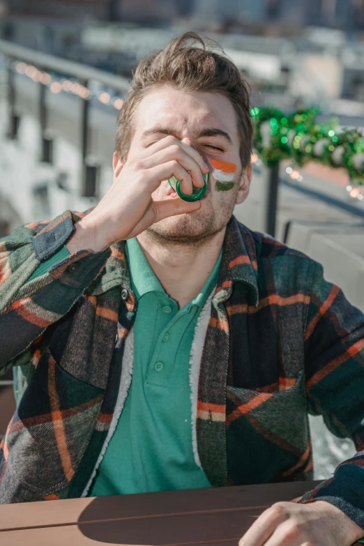 a man sitting at a table with a donut in his mouth, trending on reddit, drinking a beer, irish genes, wearing green jacket, shots fired