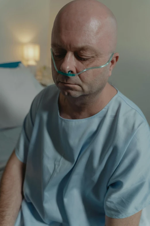 a man in a hospital gown sitting on a bed, hard breathing, worksafe. cinematic, profile image