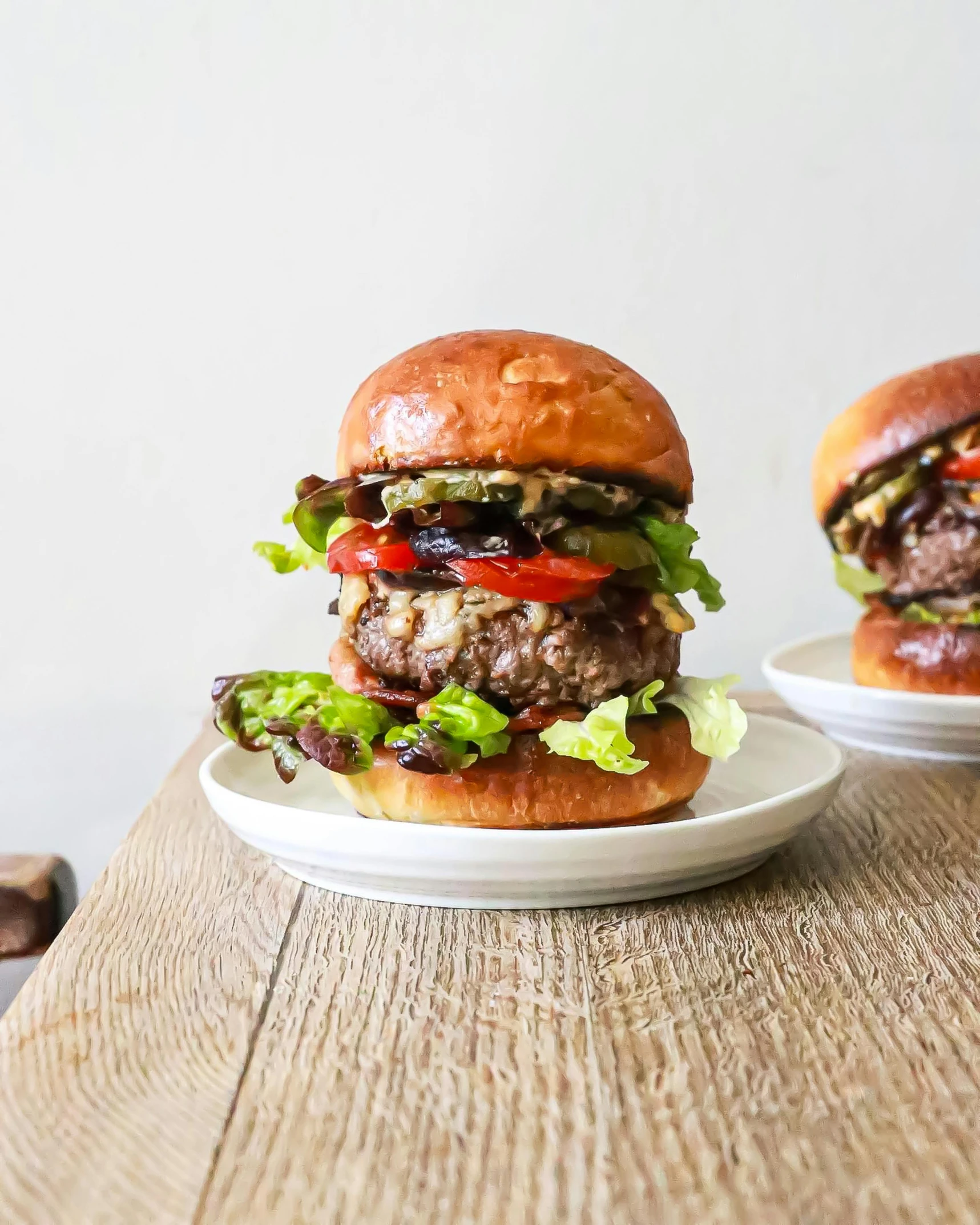 a couple of hamburgers sitting on top of a wooden table, by Julia Pishtar, profile image