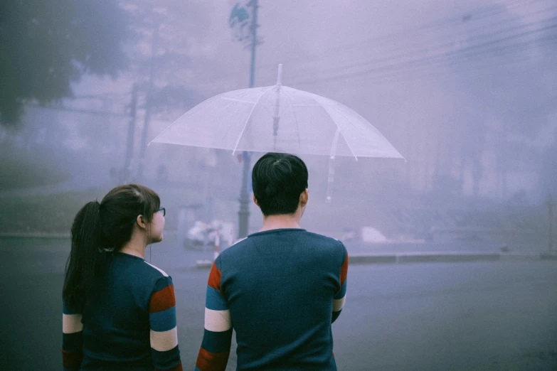 a man and a woman standing under an umbrella, inspired by Zhang Xiaogang, pexels contest winner, conceptual art, pale blue fog, vhs colour photography, purple fog, spring day