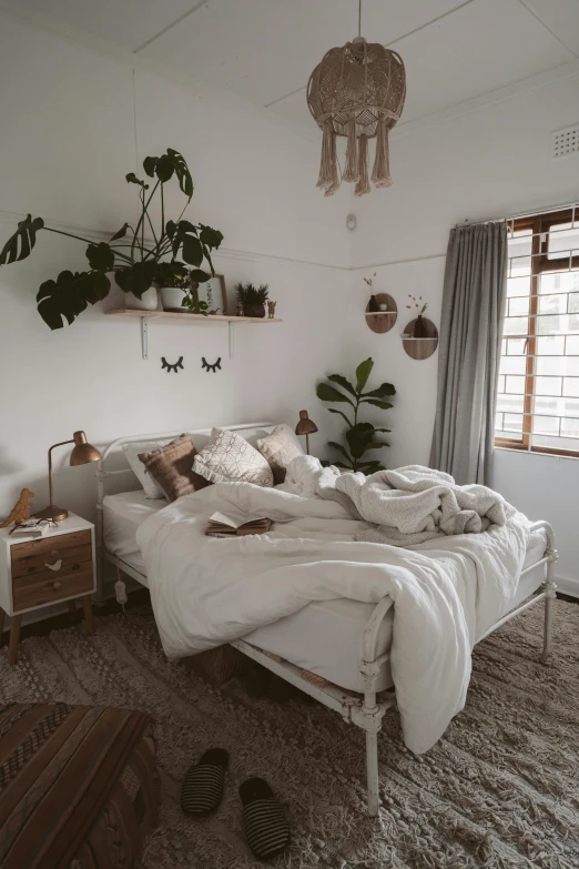 a bed sitting in a bedroom next to a window, by Elsie Henderson, unsplash contest winner, light and space, romantic greenery, things hanging from ceiling, brown and white color scheme, snapchat photo