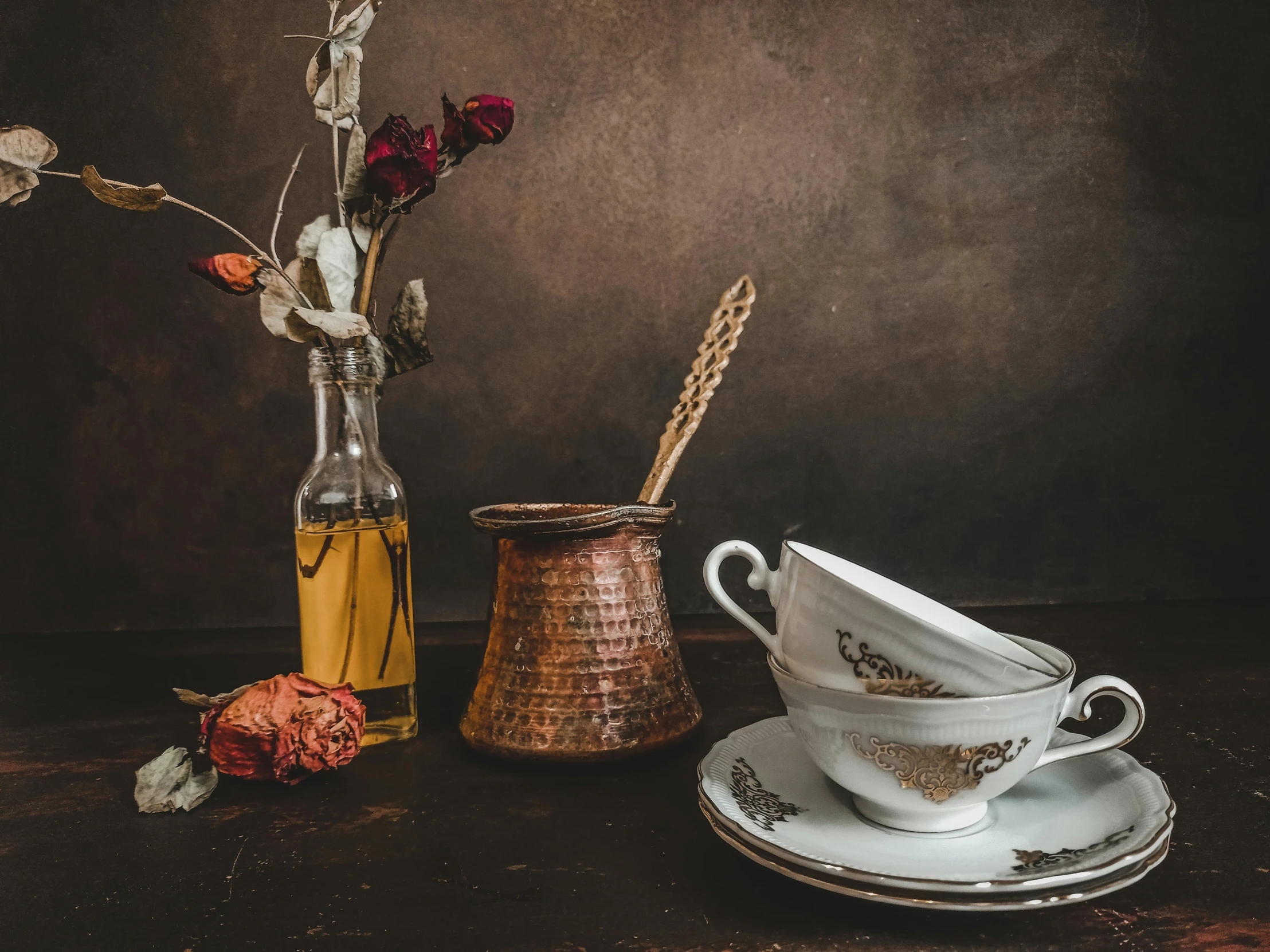 a couple of cups and saucers sitting on a table, a still life, pexels contest winner, dried flower, profile image, old style photo, rusted junk