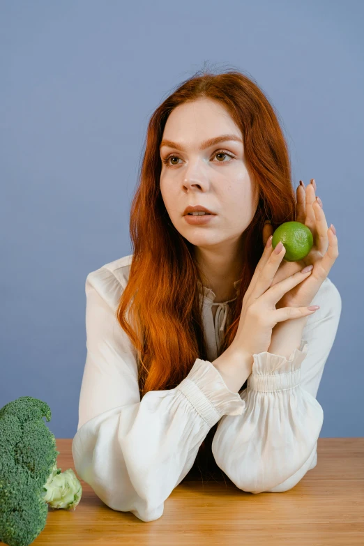 a woman sitting at a table with broccoli and an apple, inspired by Elsa Bleda, unsplash, renaissance, long ginger hair, patricia piccinini, low quality photo, portrait of anya taylor-joy