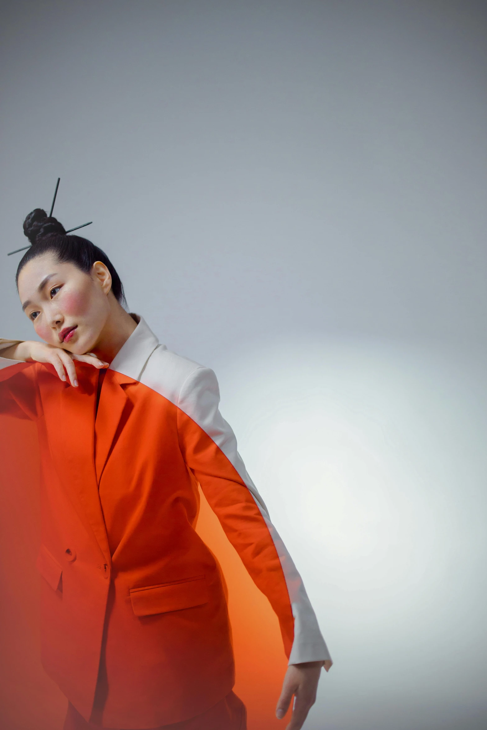 a woman in an orange suit posing for a picture, an album cover, inspired by Gao Xiang, unsplash, topknot, maggie cheung, on a gray background, with a white background