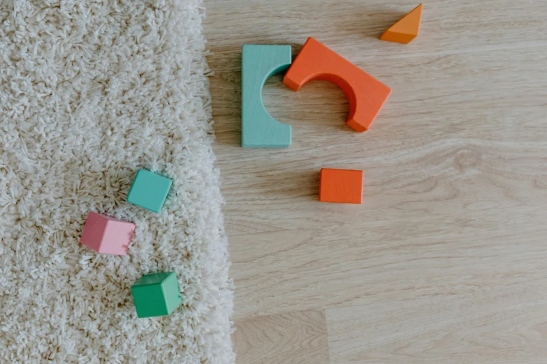 a pile of toys sitting on top of a wooden floor, inspired by Frederick Hammersley, pexels contest winner, carpet, abstract blocks, thumbnail, minimalissimo