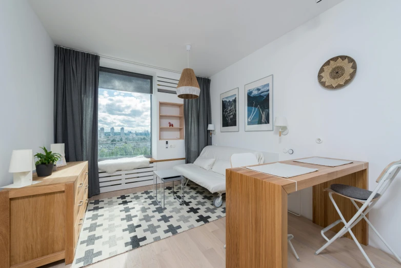 a white couch sitting in a living room next to a window, a portrait, by Alexander Fedosav, unsplash, small and cosy student bedroom, skyline showing from the windows, czeslaw znamierowski, dwell