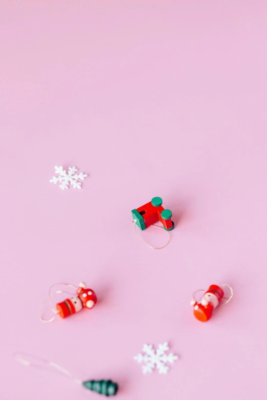 a bunch of christmas decorations on a pink surface, by Sam Havadtoy, earbuds, mini model, detail shot, elves