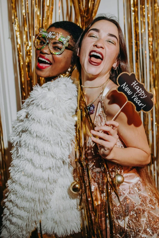 a couple of women standing next to each other, a picture, trending on pexels, renaissance, new years eve, photo booth, both laughing, marble and hint gold