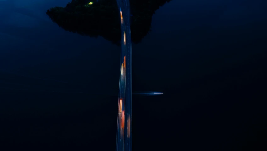 a car is driving down the road at night, by Sebastian Spreng, pexels contest winner, conceptual art, treading above calm water, top down, bridges, slightly pixelated