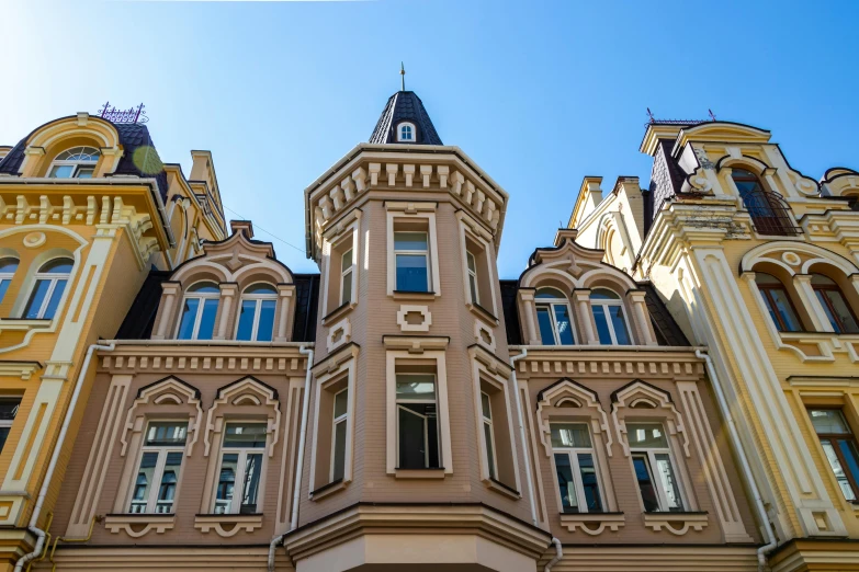 a tall building with a clock on the front of it, inspired by Albert Paris Gütersloh, pexels contest winner, art nouveau, sand - colored walls, helsinki, profile image, square