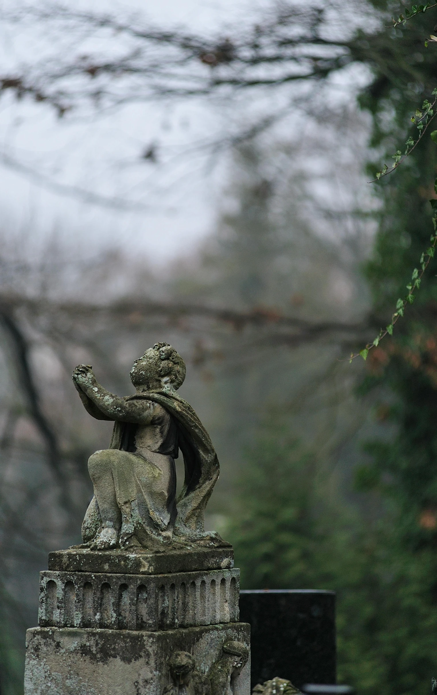 a statue of a woman sitting on top of a grave, a statue, by Sebastian Spreng, pexels contest winner, romanticism, rainy day outside, perched on a mossy branch, slightly pixelated, high quality photo