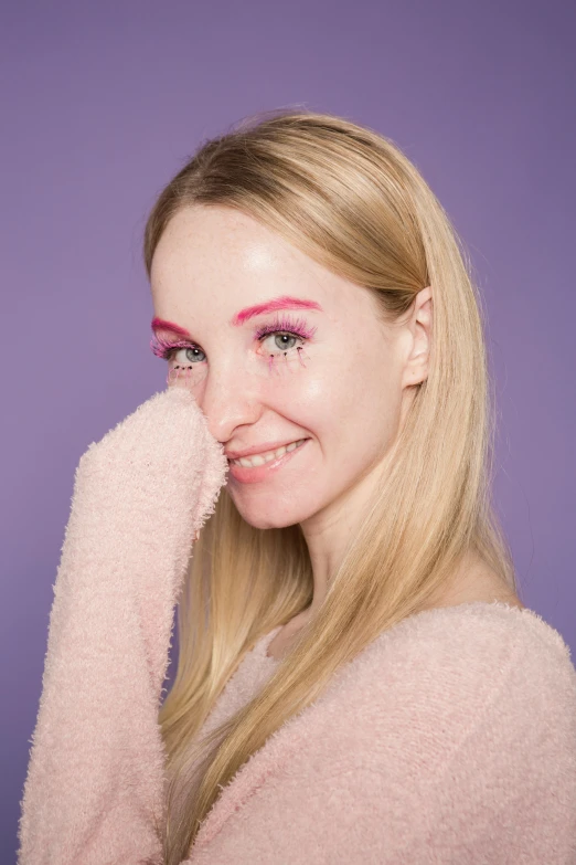 a woman with pink eyeliners posing for a picture, an album cover, inspired by Louisa Matthíasdóttir, trending on pexels, looking happy, anastasia ovchinnikova, plain background, soft and fluffy