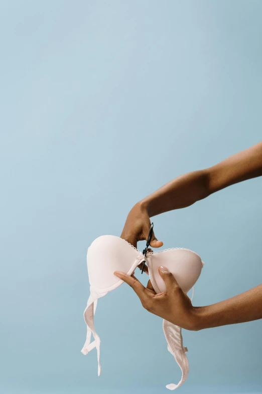 a woman in a white dress holding a pink bra, unsplash, opening, surgery, 3/4 front view, slide show