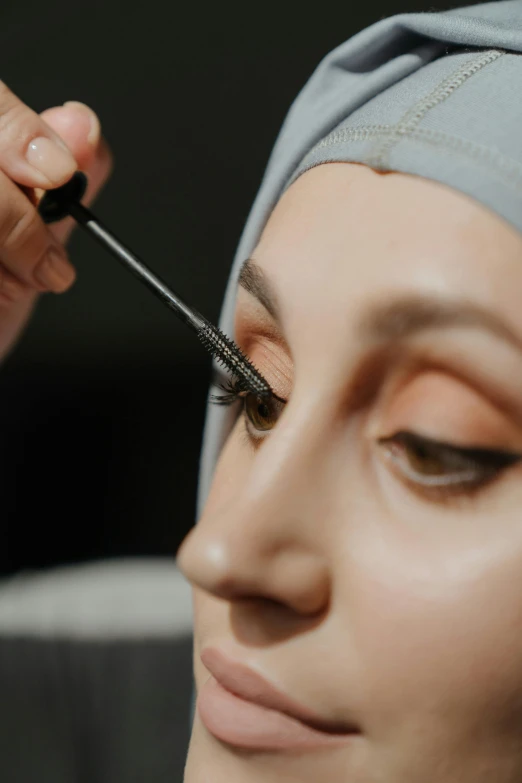 a woman with a turban is doing makeup, a hyperrealistic painting, pexels contest winner, hurufiyya, detailed lashes, put on a mannequin, islamic, high angle close up shot