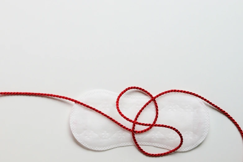 a pair of eye pads tied to a string, inspired by Louise Bourgeois, trending on pexels, plasticien, white, red-fabric, blank, bra
