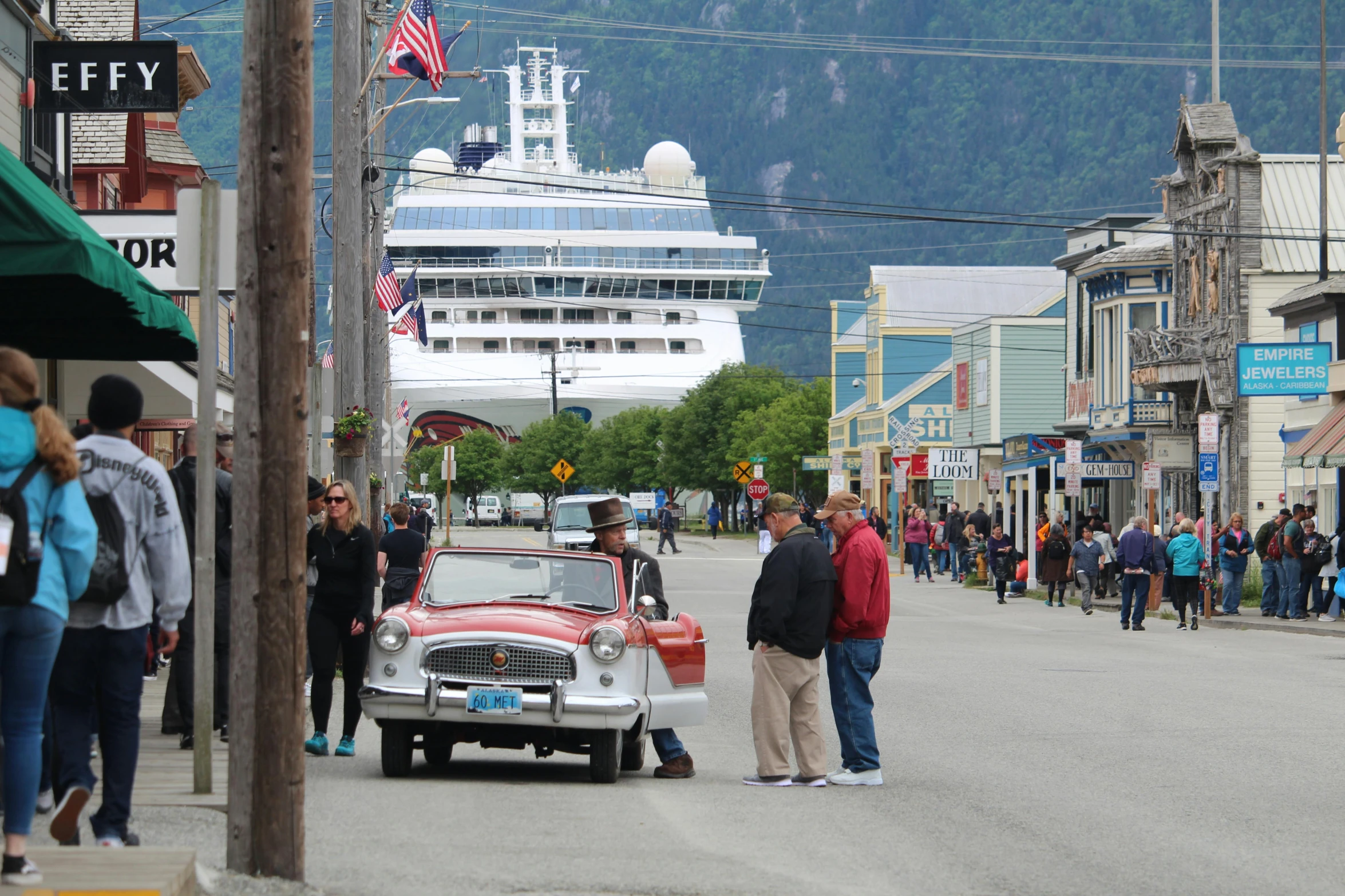 a group of people standing on the side of a road, docked at harbor, pop culture, bc, town square