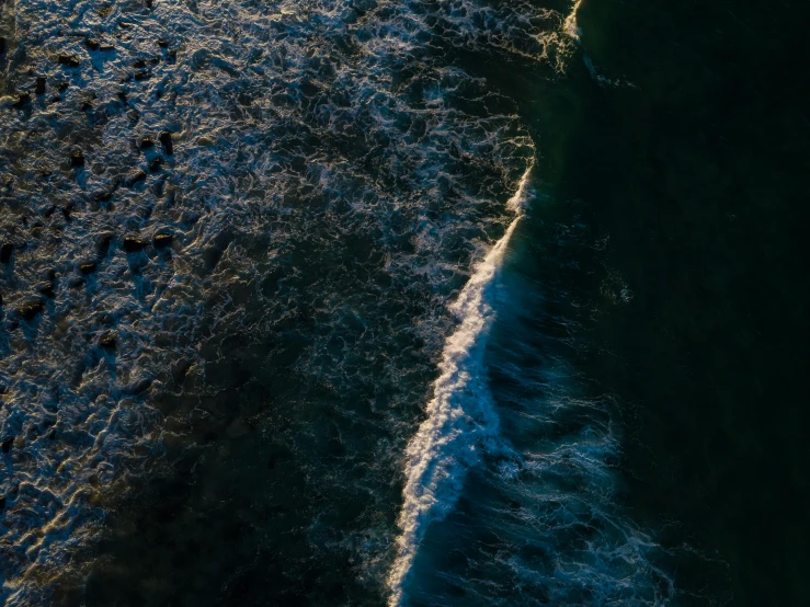 a group of people riding surfboards on top of a wave, aerial photography, dimly - lit, /r/earthporn, coastline