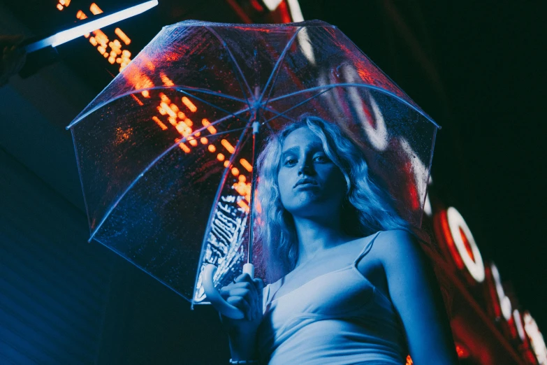 a woman holding an umbrella in front of a neon sign, inspired by Elsa Bleda, unsplash contest winner, portrait of kim petras, blue shiny lighting, bladerunner in the rain, reflecting light in a nightclub