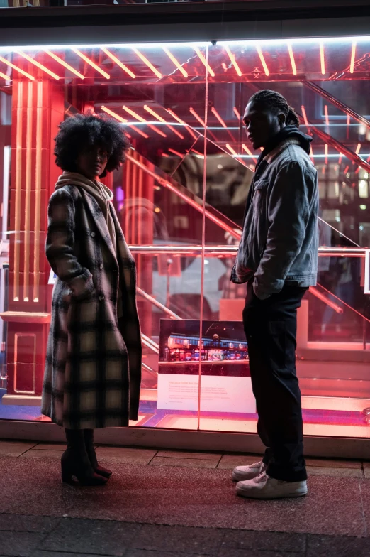 a couple of people standing in front of a store, pexels contest winner, afrofuturism, perfectly lit. movie still, cold lighting, calmly conversing 8k, from the new john wick movie