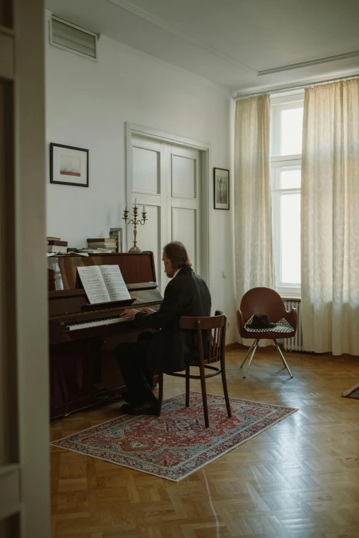 a woman sitting at a piano in a living room, an album cover, inspired by Emanuel Schongut, unsplash, jama jurabaev, man sitting facing away, in legnica, wide film still