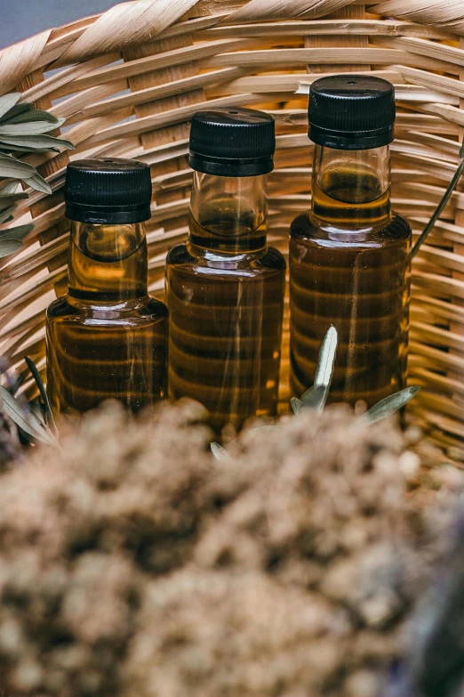 a wicker basket filled with bottles of essential oils, by Julia Pishtar, pexels contest winner, renaissance, 3 - piece, made of bees, texture, savory