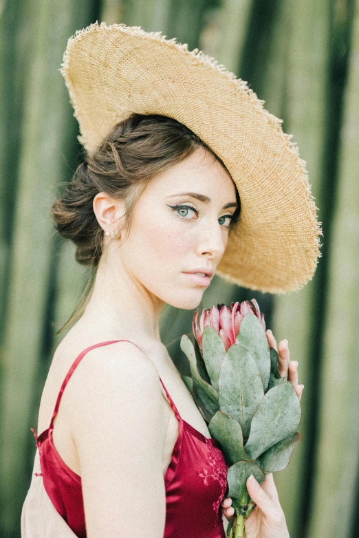 a woman in a straw hat holding a flower, a portrait, by Sara Saftleven, pexels contest winner, gorgeous young alison brie, cactus, square, eucalyptus