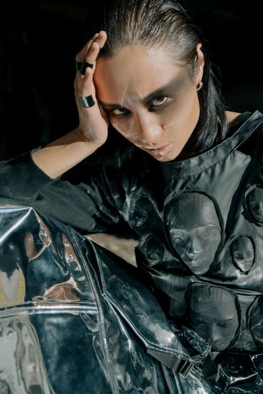 a beautiful young woman sitting on top of a motorcycle, an album cover, inspired by Taro Yamamoto, trending on cg society, gothic art, photograph of a techwear woman, with black metal face paint, wears a spacesuit, androgynous male