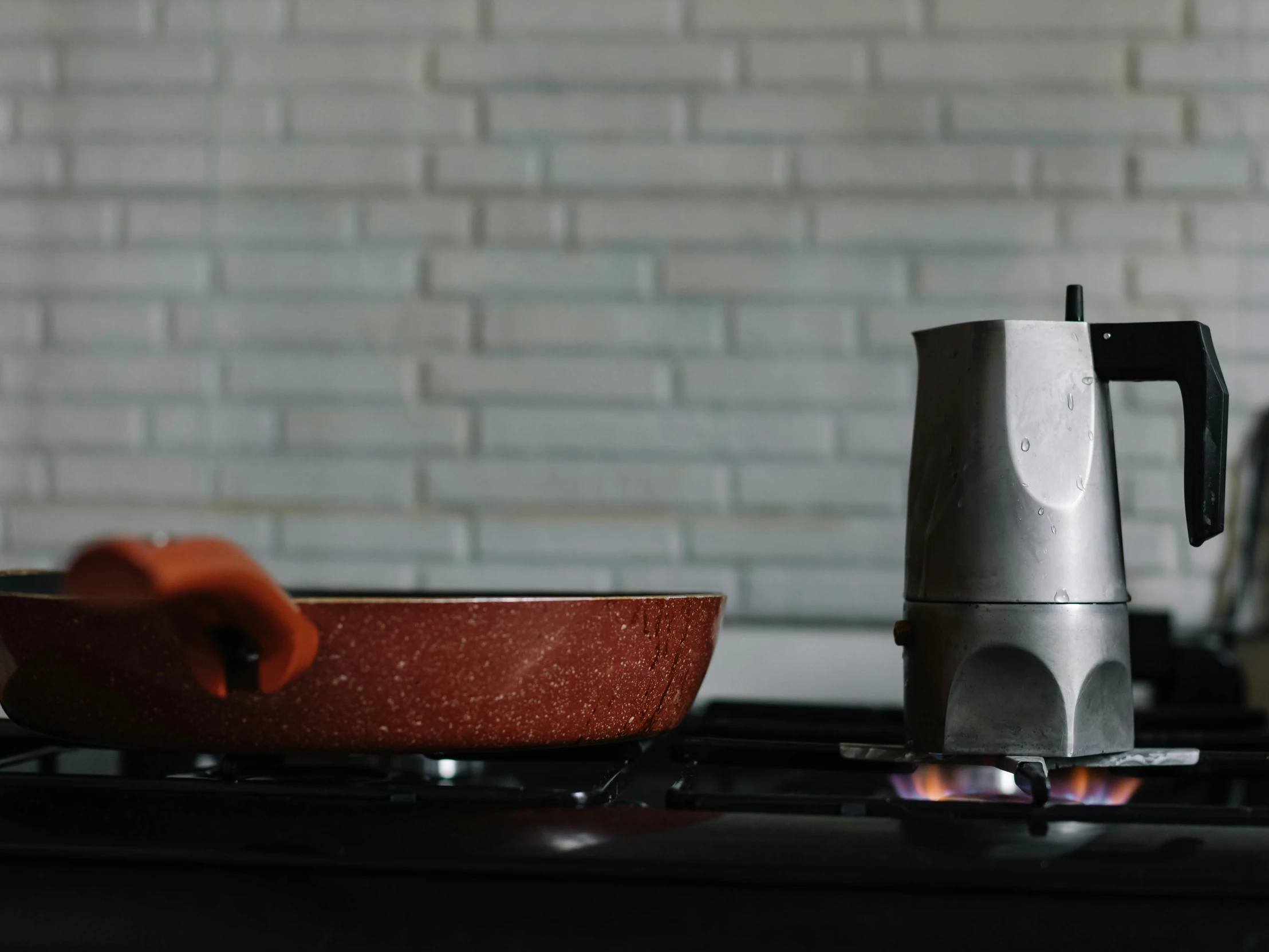 a coffee pot sitting on top of a stove next to a frying pan, pexels contest winner, wearing a red turtleneck sweater, raku, innovative product concepts, background image