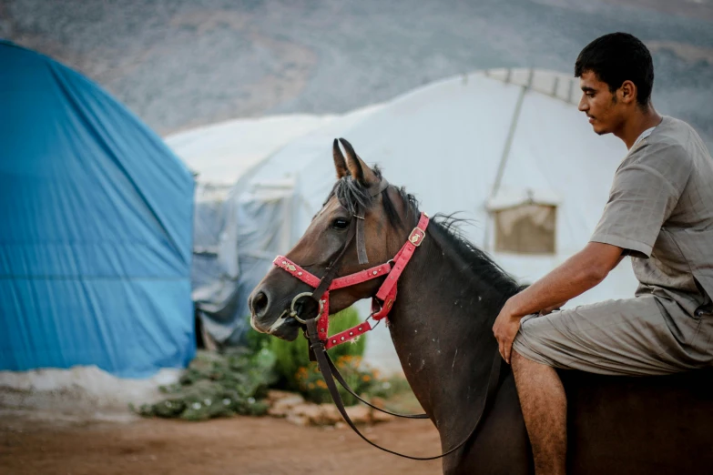 a man riding on the back of a brown horse, pexels contest winner, real life photo of a syrian man, he is at camp, profile image, greek ameera al taweel