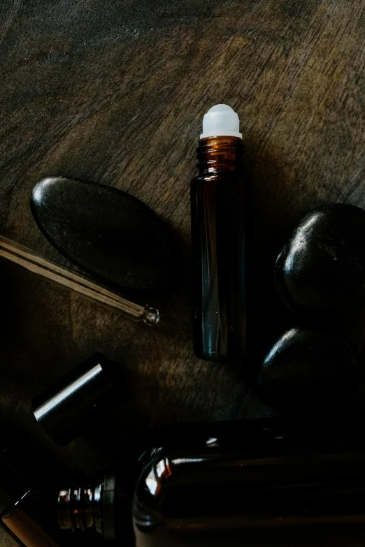 a bottle of perfume sitting on top of a wooden table, dark rocks, healing tubes, thumbnail, tools