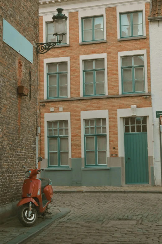 a red scooter parked in front of a brick building, inspired by Pieter de Hooch, pexels contest winner, teal and orange color scheme, streetview, in front of a two story house, belgium