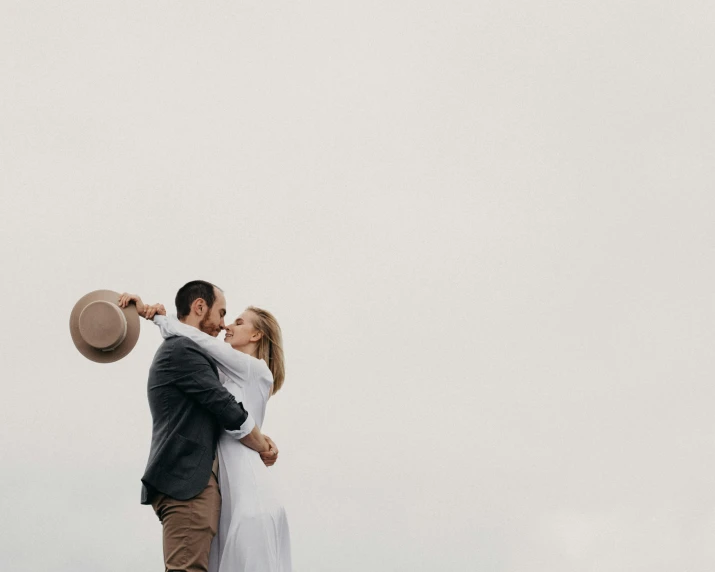 a man and a woman standing next to each other, unsplash contest winner, romanticism, background image, neutral sky, couple dancing, stacked image