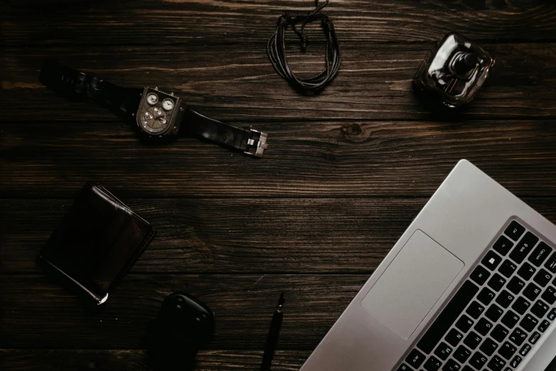 a laptop computer sitting on top of a wooden table, by Adam Marczyński, trending on pexels, black jewellery, brown, knolling, dials