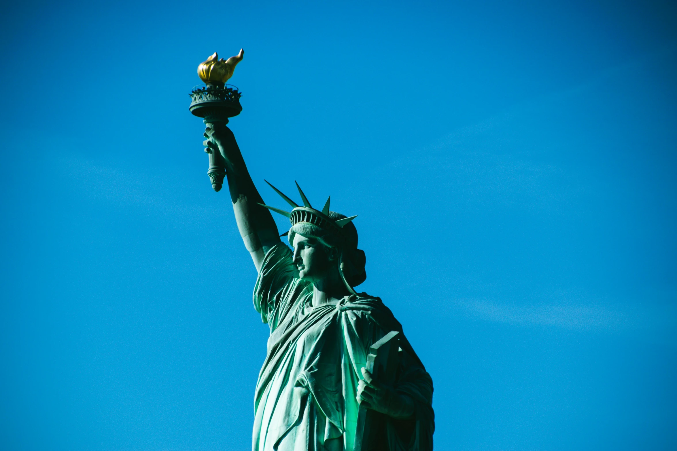 a close up of a statue of liberty against a blue sky, a statue, by Matija Jama, pexels contest winner, 🦩🪐🐞👩🏻🦳, the torch we all must hold, statue of the perfect woman, slide show