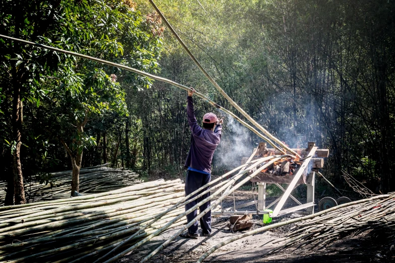 a man that is standing in the dirt, in a bamboo forest, worksafe. instagram photo, weaving, smoking