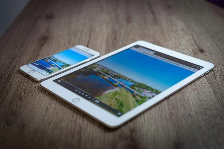 a tablet computer sitting on top of a wooden table, by Niko Henrichon, unsplash, photorealism, beautiful iphone wallpaper, 2 5 6 x 2 5 6, split screen, multi-dimensional