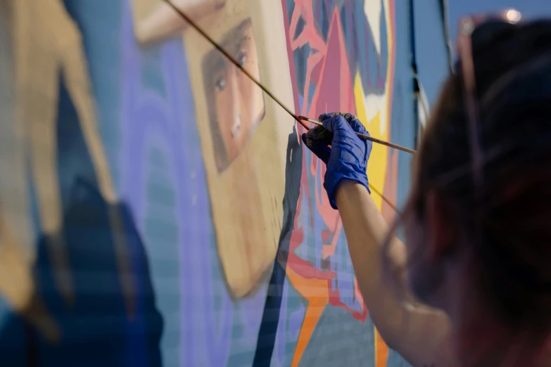 a woman painting a mural on the side of a building, a detailed painting, by Julia Pishtar, pexels contest winner, graffiti, james gilleard and james jean, medium close up shot, thumbnail, hanging