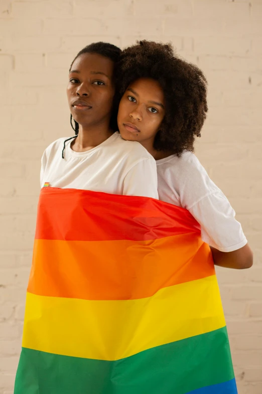 a man and a woman holding a rainbow flag, by Lily Delissa Joseph, black teenage boy, holding each other, official product photo, waist up