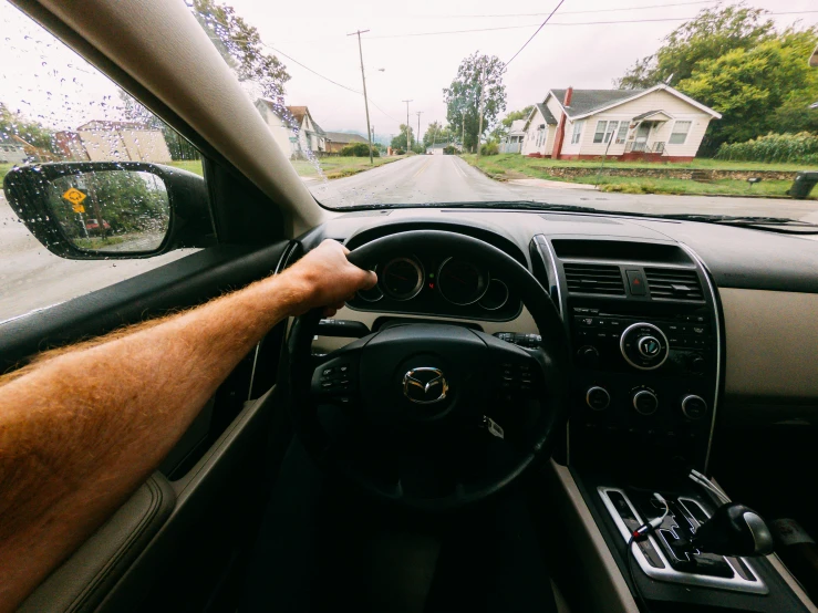 a hand on the steering wheel of a car, an album cover, unsplash, handsome, mr beast, long distance photo, walking through a suburb