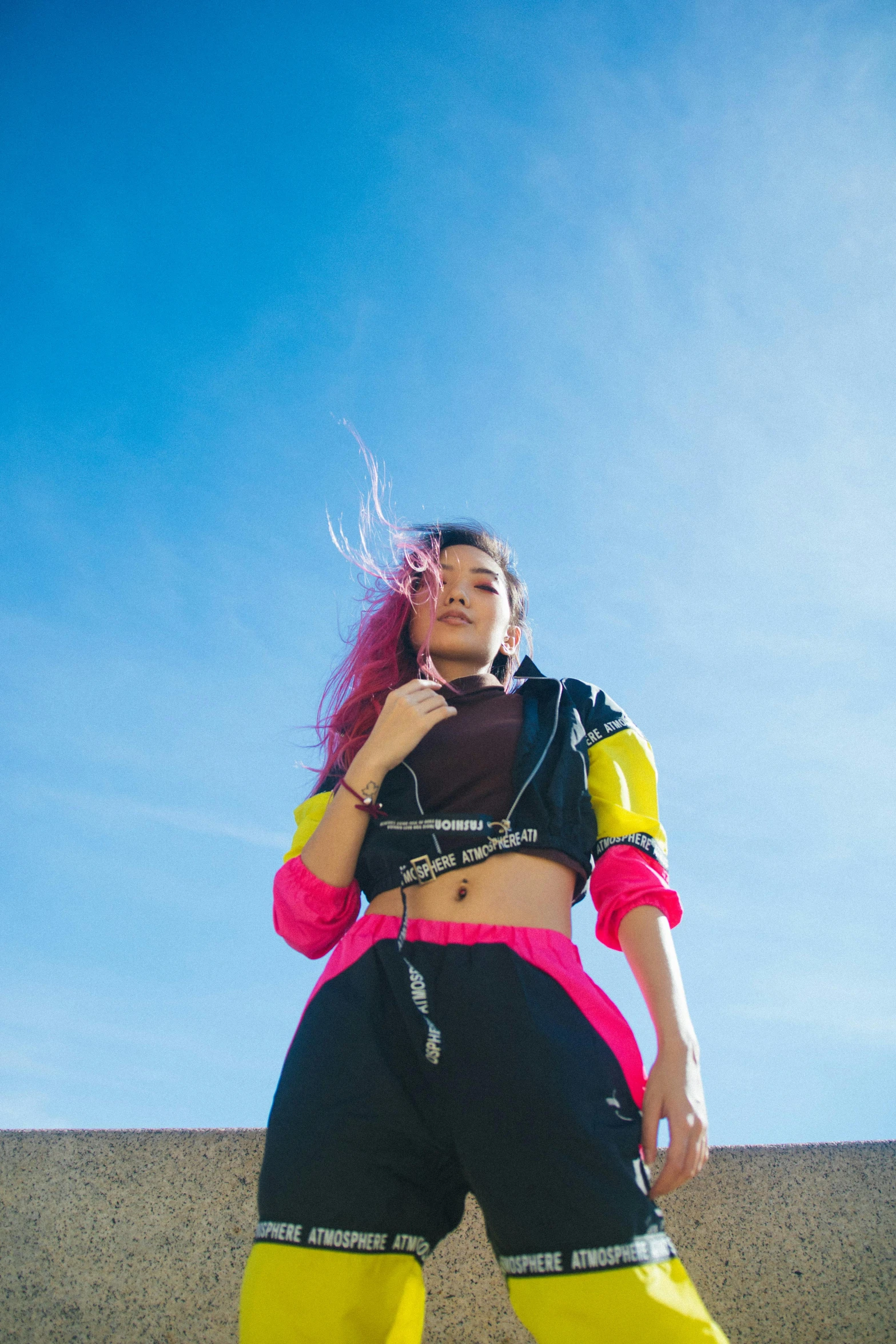 a woman with pink hair standing on a skateboard, trending on pexels, black and yellow tracksuit, sky view, rave outfit, asher duran