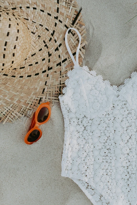 a white one piece swimsuit next to a straw hat, trending on unsplash, intricate and detailed lace set, with sunglass, orange and white, textured