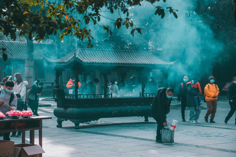 a group of people that are standing in the street, inspired by Hu Zao, pexels contest winner, an altar of a temple, cyan mist, praying with tobacco, time travelers appear in a park