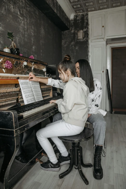 a couple of people that are sitting at a piano