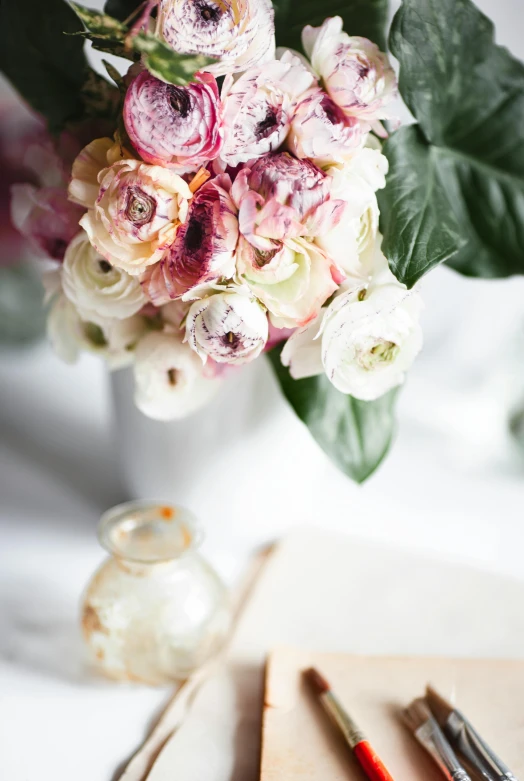 a vase filled with flowers sitting on top of a table, inspired by François Boquet, unsplash, romanticism, writing in journal, silver and muted colors, exquisite marble details, peony flowers