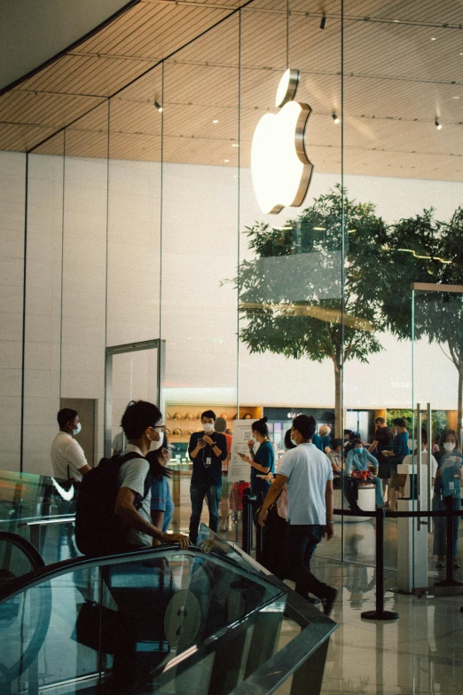 a group of people standing around an apple store, a picture, unsplash, hyperrealism, fuji superia, apple car, iphone 13, low quality photo